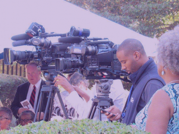News cameras and reporters covering an Oberlin event.