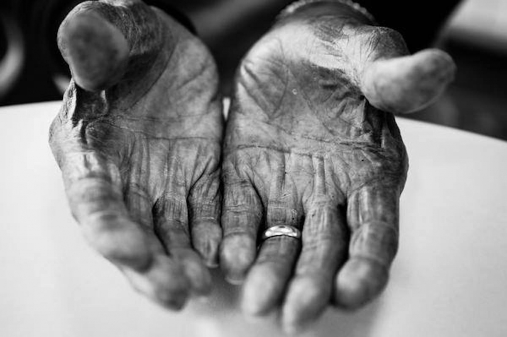 Closeup of Mr. Curtis's 96 year old hands cupped up to show his palms. He is wearing a ring. Black and white.