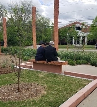 Two people sitting on a bench at Oberlin Rising park.